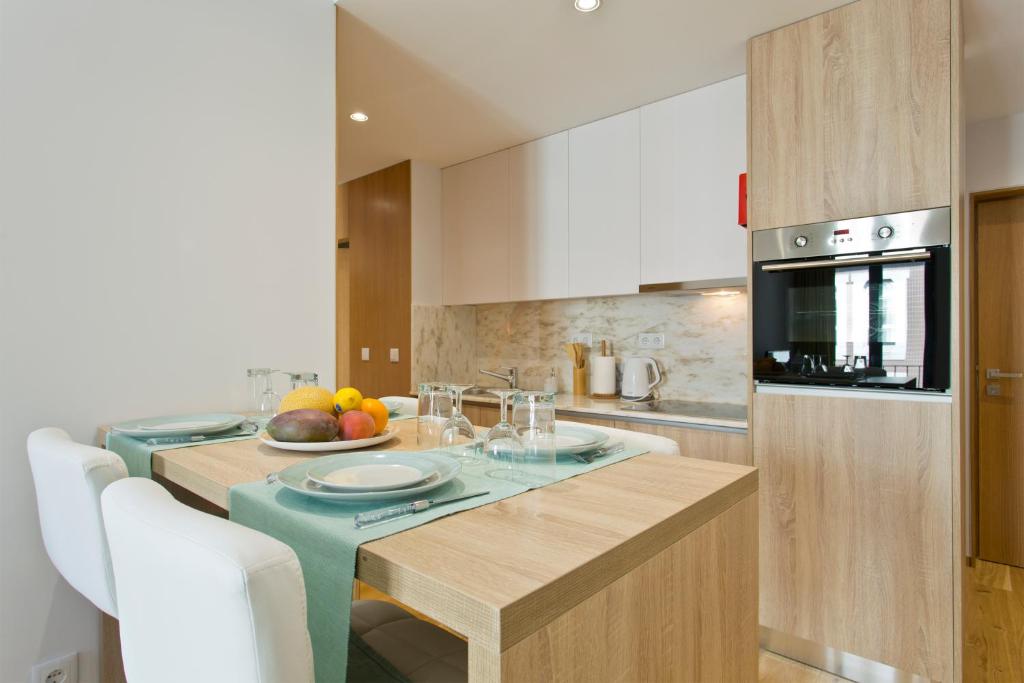 a kitchen with a table with a bowl of fruit on it at OTF- Porto Centro in Porto