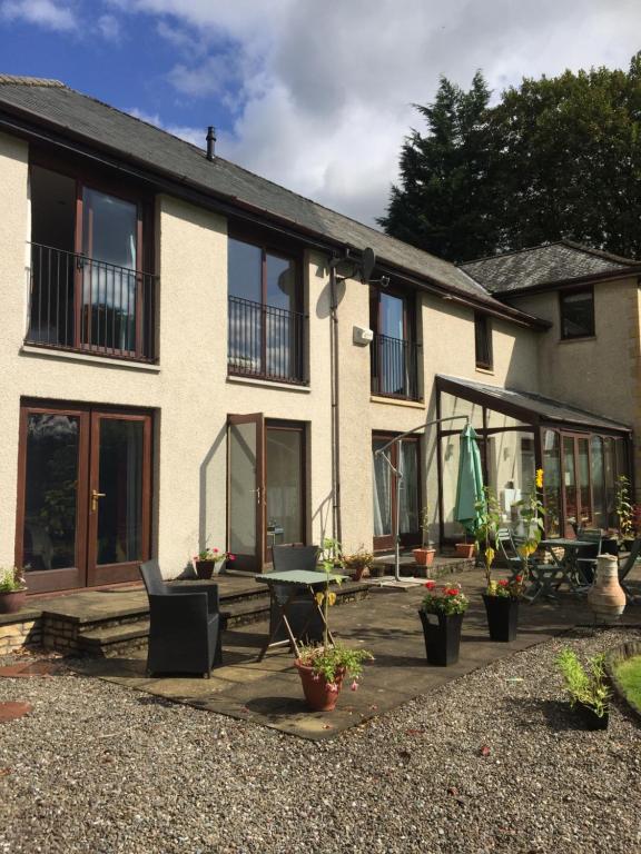 a house with a patio and a table and chairs at Riverside House in Callander