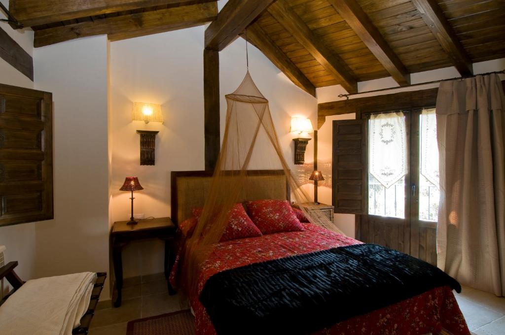 1 dormitorio con 1 cama con dosel de madera en Casa Tio Conejo, en San Román de Cameros