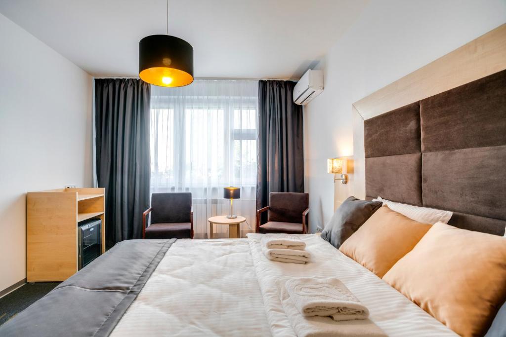 モスクワにあるLadomir Perovoの大きなベッドと椅子が備わるホテルルームです。