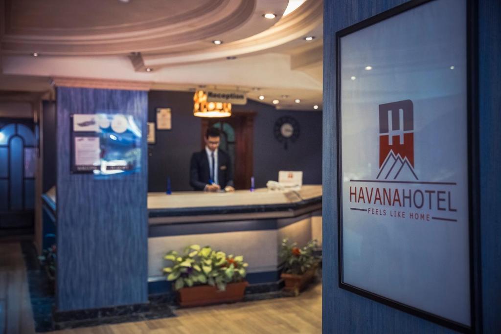 a man in a suit sitting at a reception desk at Havana Hotel Cairo in Cairo