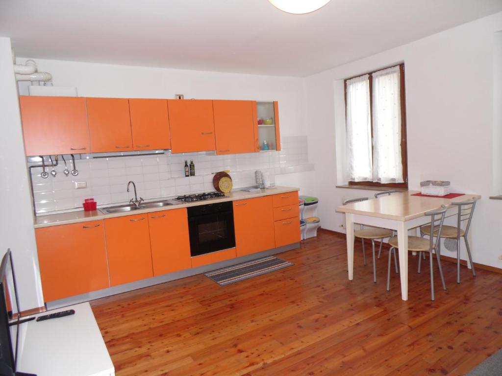una cocina con armarios naranjas y una mesa. en Mini Viale Farra, en Feltre
