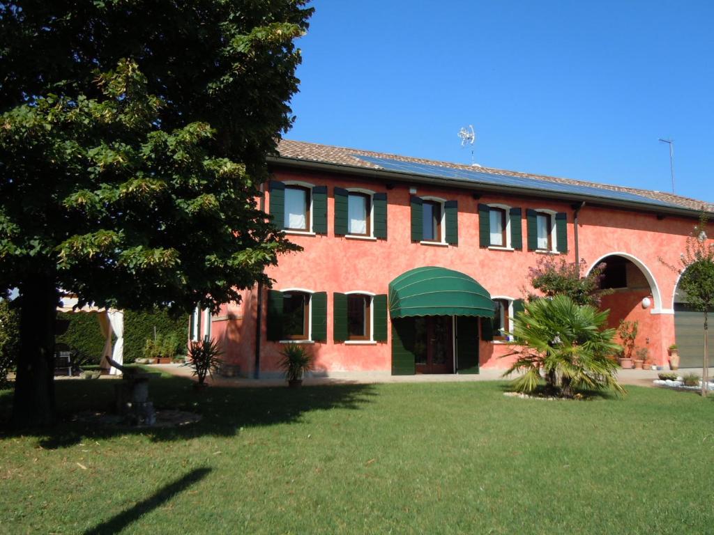 un edificio de ladrillo rojo con toldo verde en Il Farfasole, en Vigonovo