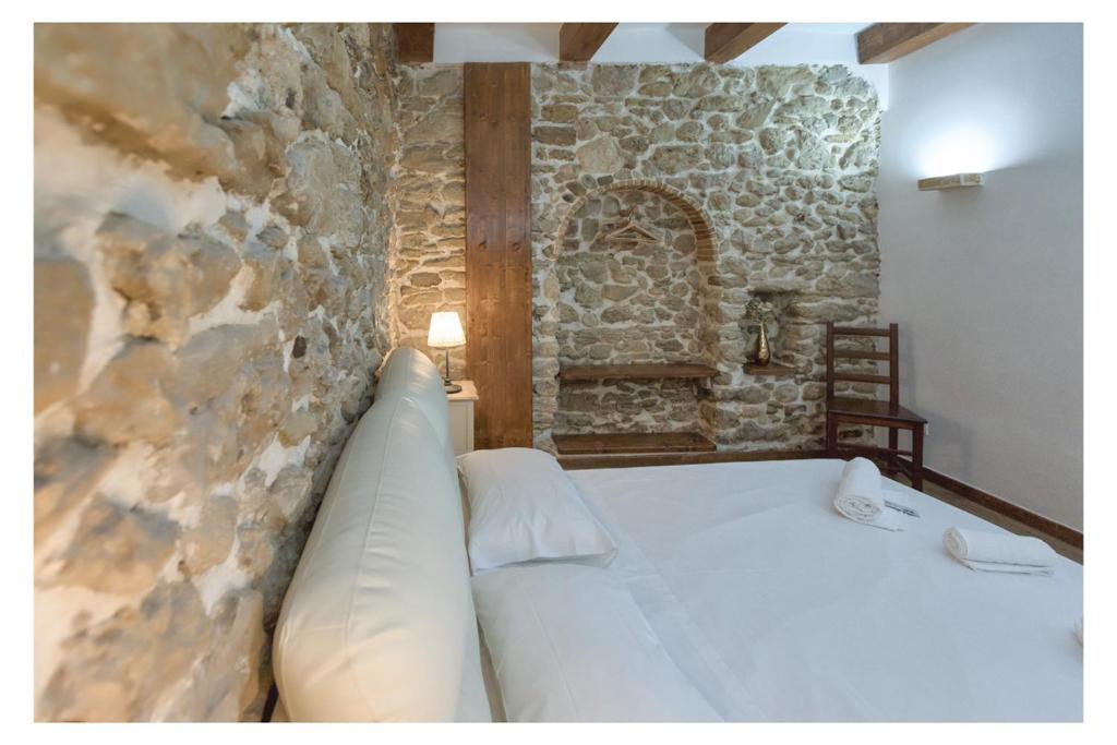 a bed in a room with a stone wall at Dependance Ludovica in Termoli