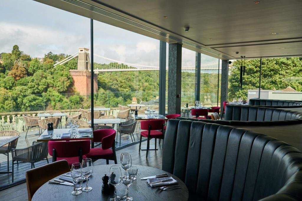 Avon Gorge by Hotel du Vin في بريستول: مطعم بطاولات وكراسي ومطل على جسر