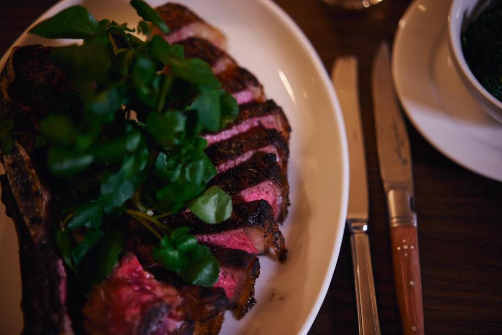 a plate with a piece of meat with greens on it at Avon Gorge by Hotel du Vin in Bristol
