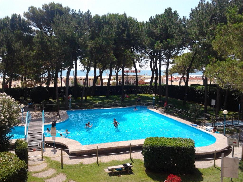 a large swimming pool with people in the water at Cristallo Residence in Lignano Sabbiadoro