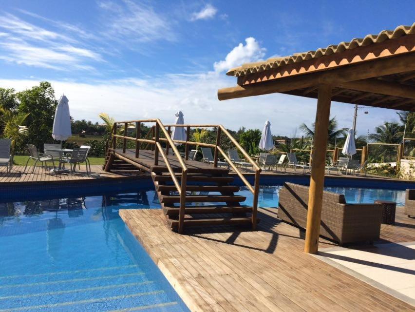 a resort with a swimming pool and a wooden deck at Reserva das Ilhas in Itacimirim