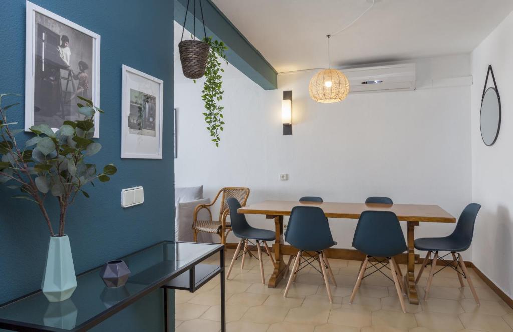 a dining room with a wooden table and blue chairs at Apartments Mar de Tossa in Tossa de Mar