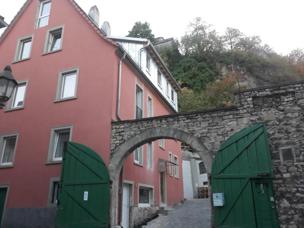 un arco entre dos edificios con puertas verdes en Mainviertelhof en Würzburg