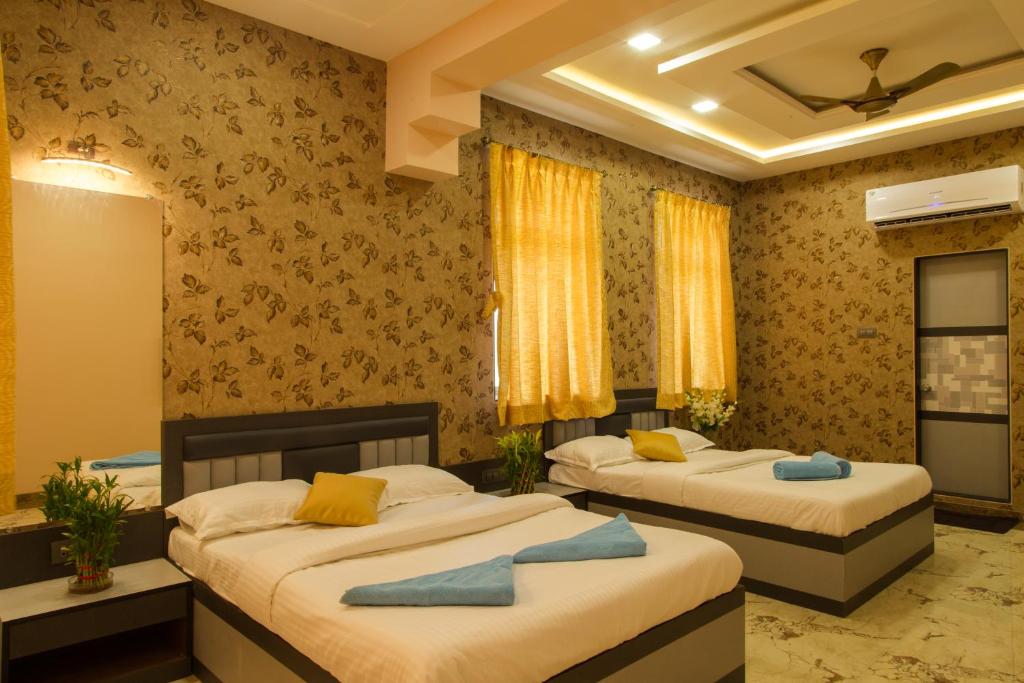 una camera con 2 letti con cuscini gialli e blu di Hotel Tourister a Mumbai
