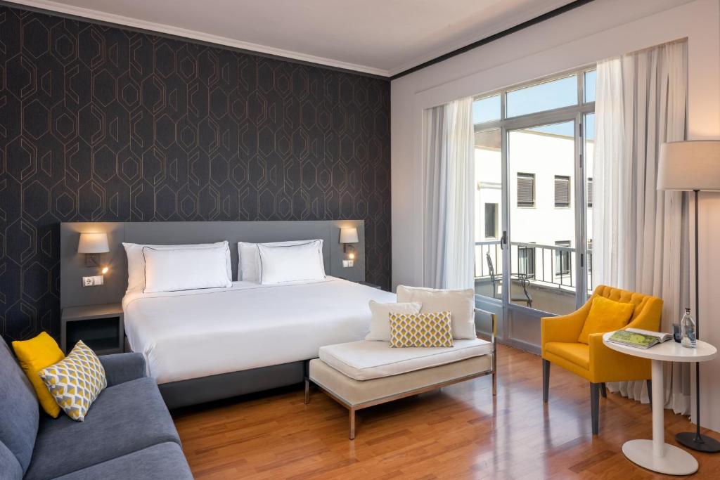 a hotel room with a bed and a couch at Hotel Madrid Plaza de España, Affiliated by Meliá in Madrid