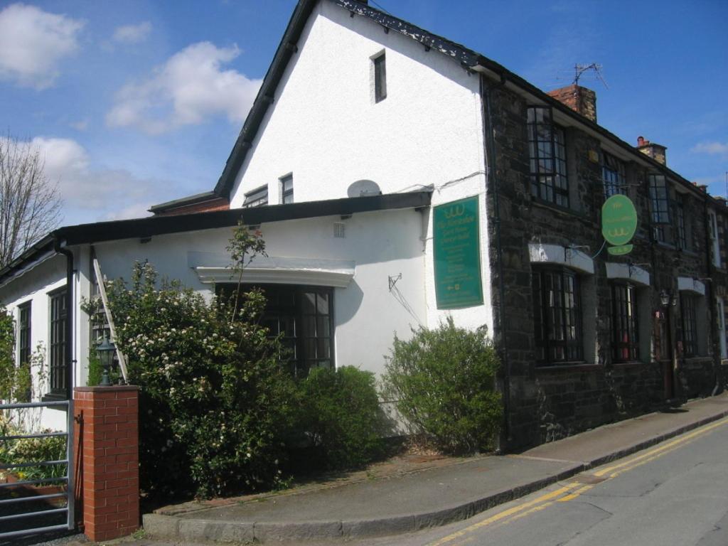 a white and black building on the side of a street at The Horseshoe Guesthouse in Rhayader