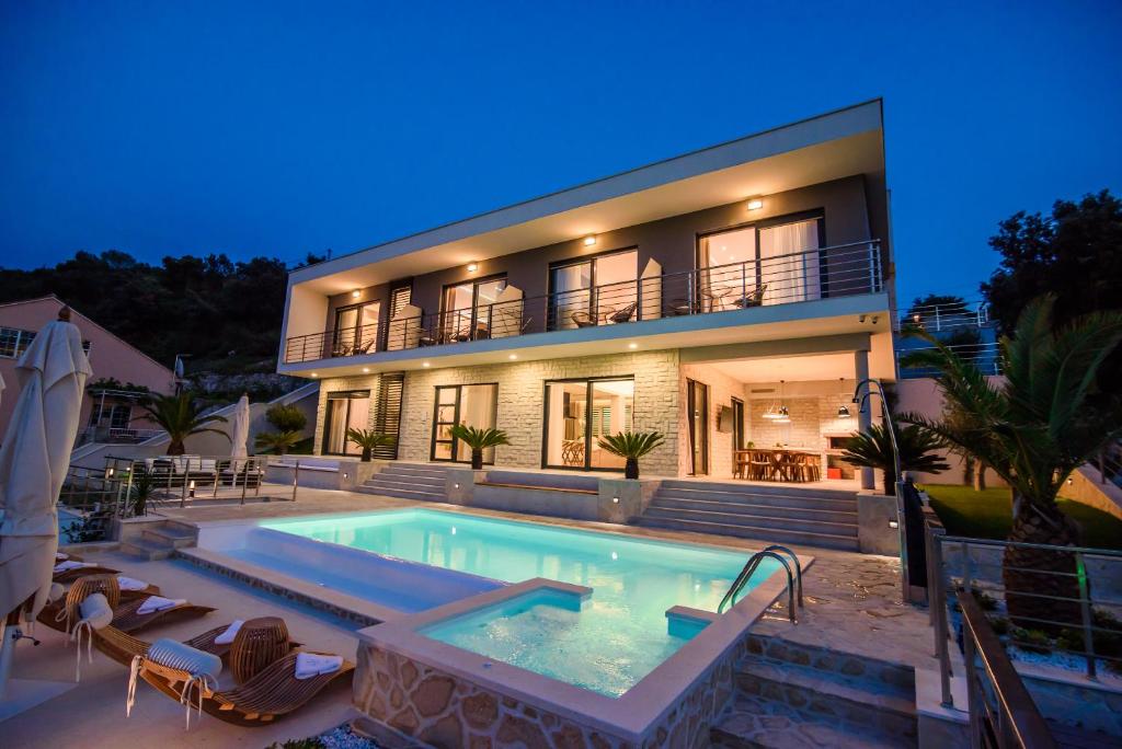 a house with a swimming pool in front of a house at VILLA TONI in Zaton