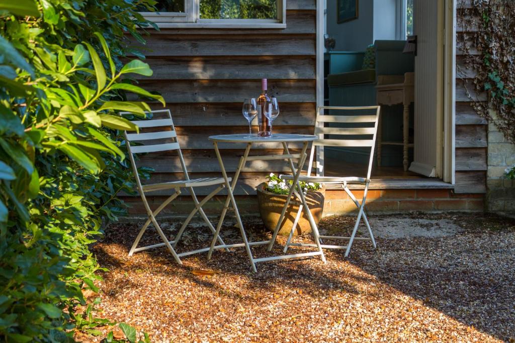 two chairs and a table with a wine glass on it at Bluebell Studio in Saxmundham