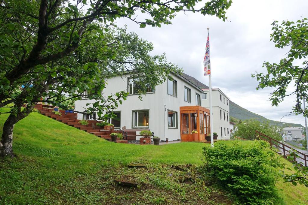 una casa en una colina con una bandera americana en The Herring House en Siglufjörður