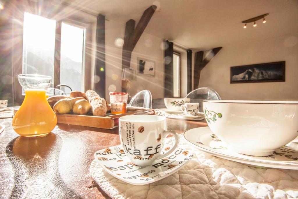 una mesa con tazas, platos y pan. en Vieux Palais - Chamonix en Chamonix-Mont-Blanc