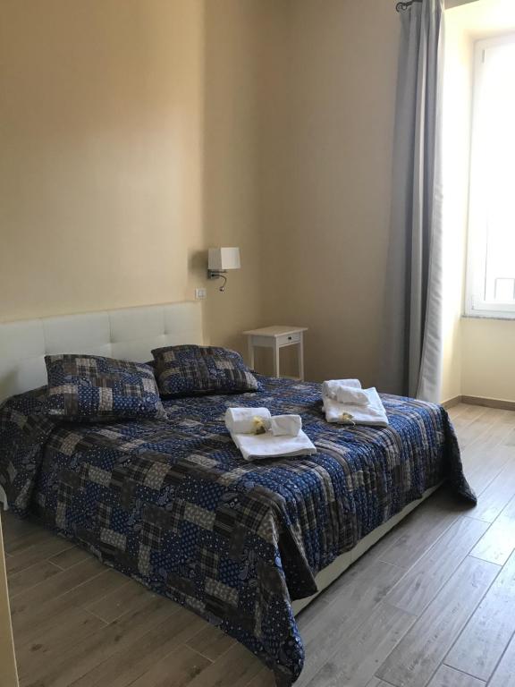 ローマにあるServenti Longhi Roomsのベッドルーム1室(ベッド1台、タオル2枚付)