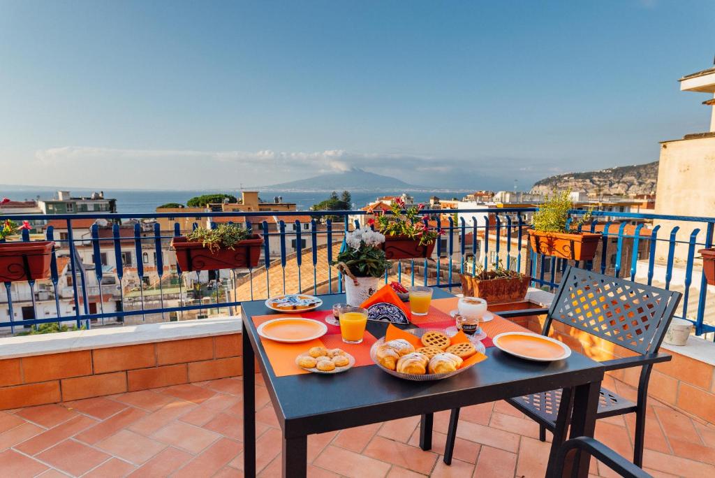 una mesa con platos de comida en el balcón en Vista Mare B&B en Sorrento