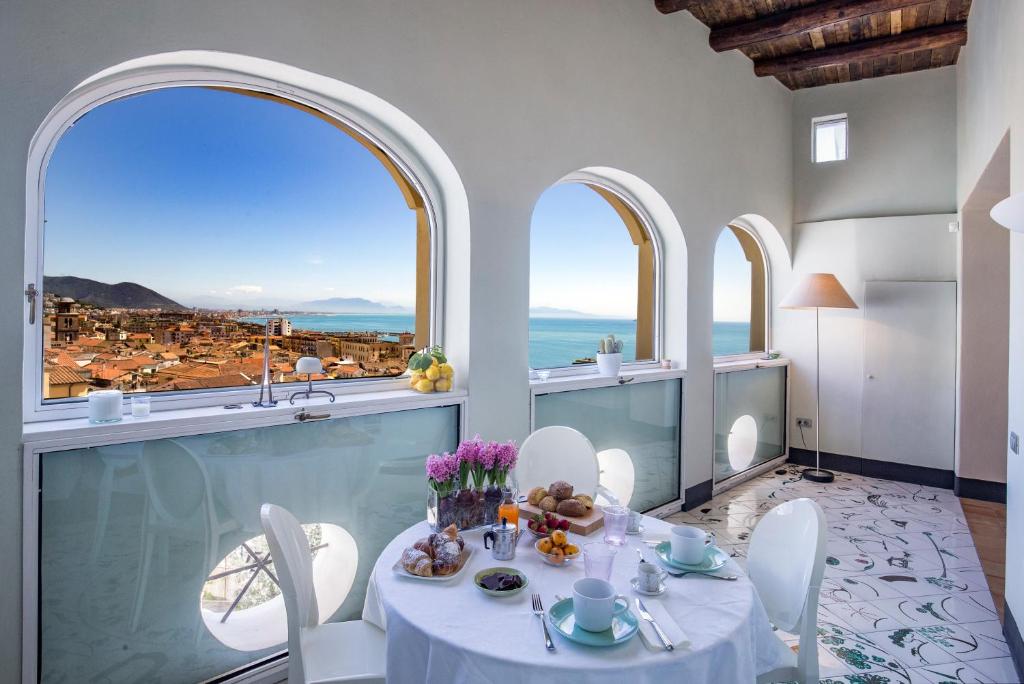 uma sala de jantar com uma mesa e vista para o oceano em Starhost - DIMORA COPETA em Salerno