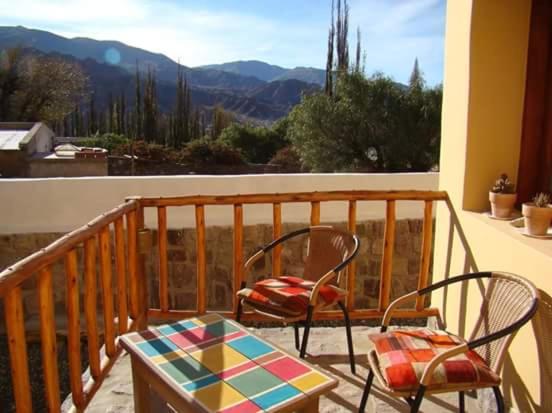 a balcony with two chairs and a table and a view at Rinconcito en Tilcara in Tilcara