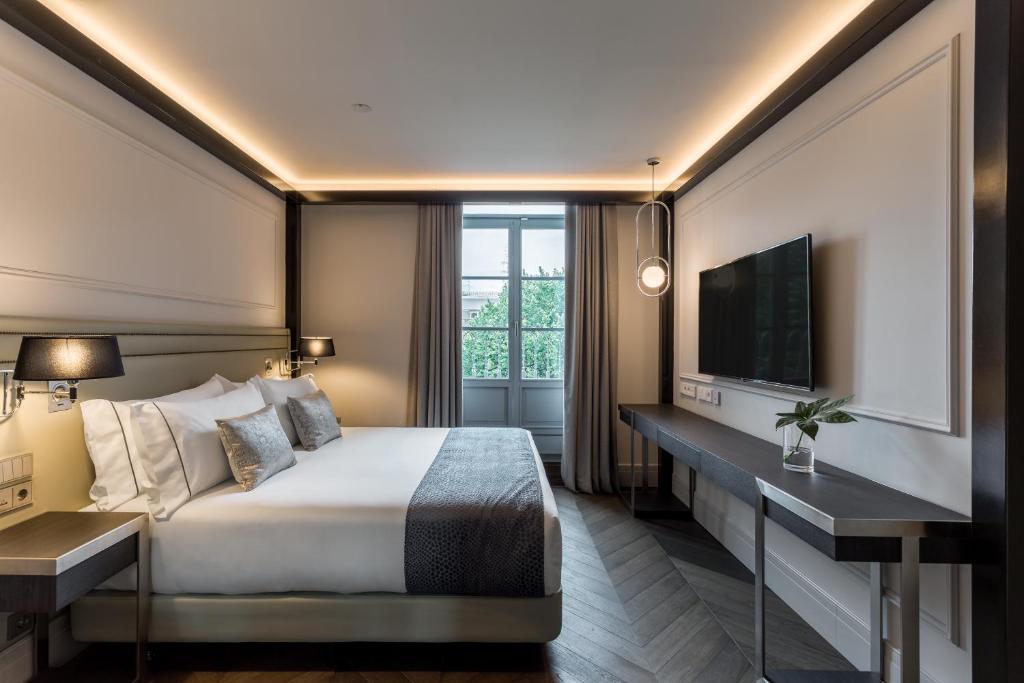um quarto de hotel com uma cama e uma televisão em Room Mate Gorka em San Sebastián