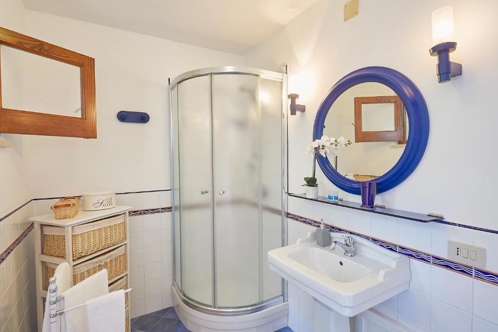 une salle de bains avec douche, lavabo et miroir dans l'établissement Villa Majus, à Porticello