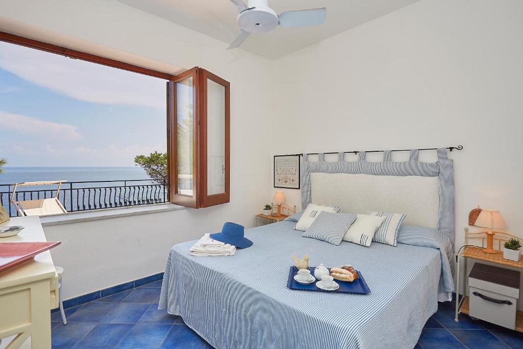 une chambre avec un lit avec vue sur l'océan dans l'établissement Villa Majus, à Porticello