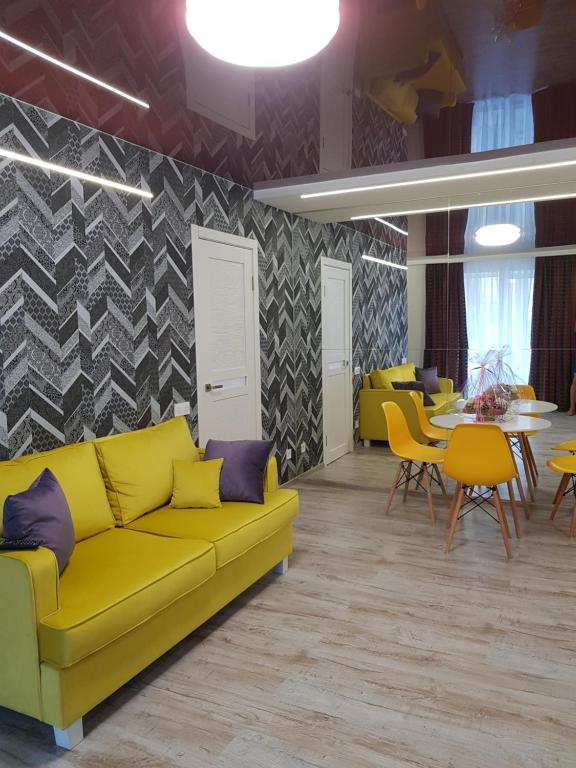 een woonkamer met een gele bank en een tafel bij Квартира Lux 2018 года in Charkov
