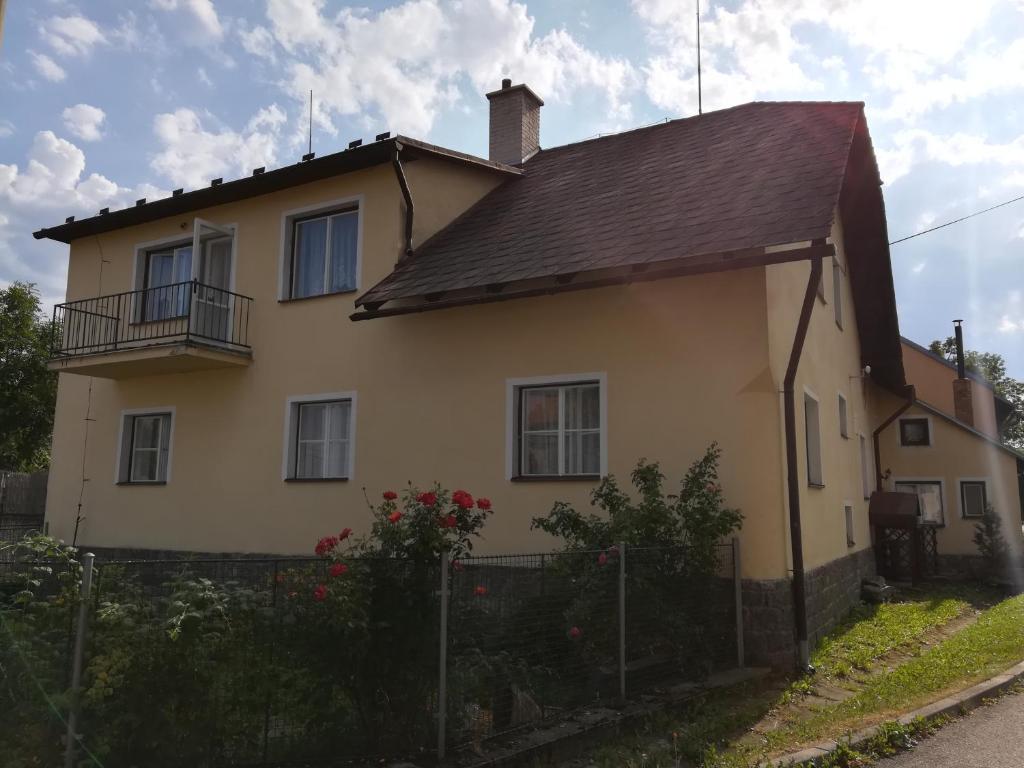 a yellow house with a fence in front of it at Penzion Kamenný Dvůr in Vimperk