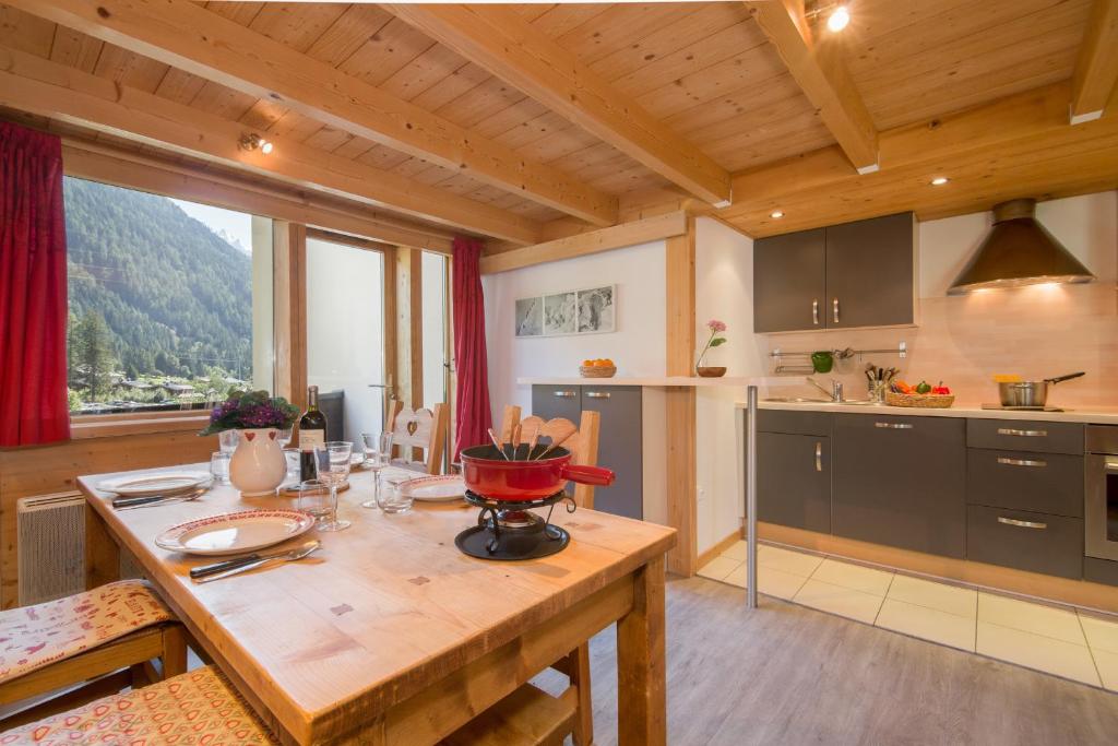 una cucina con tavolo in legno e una grande finestra di Résidence Grand Roc - Ancolies 218 - Happy Rentals a Chamonix-Mont-Blanc