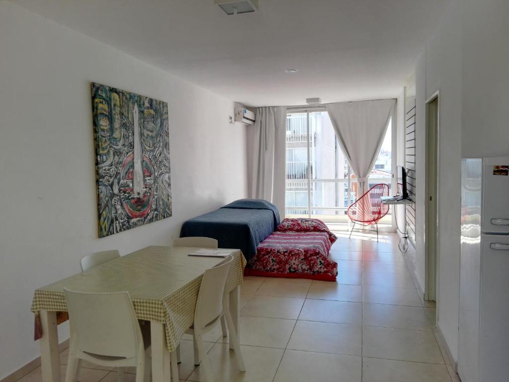 a living room with a table and a bedroom at Plaza in Buenos Aires