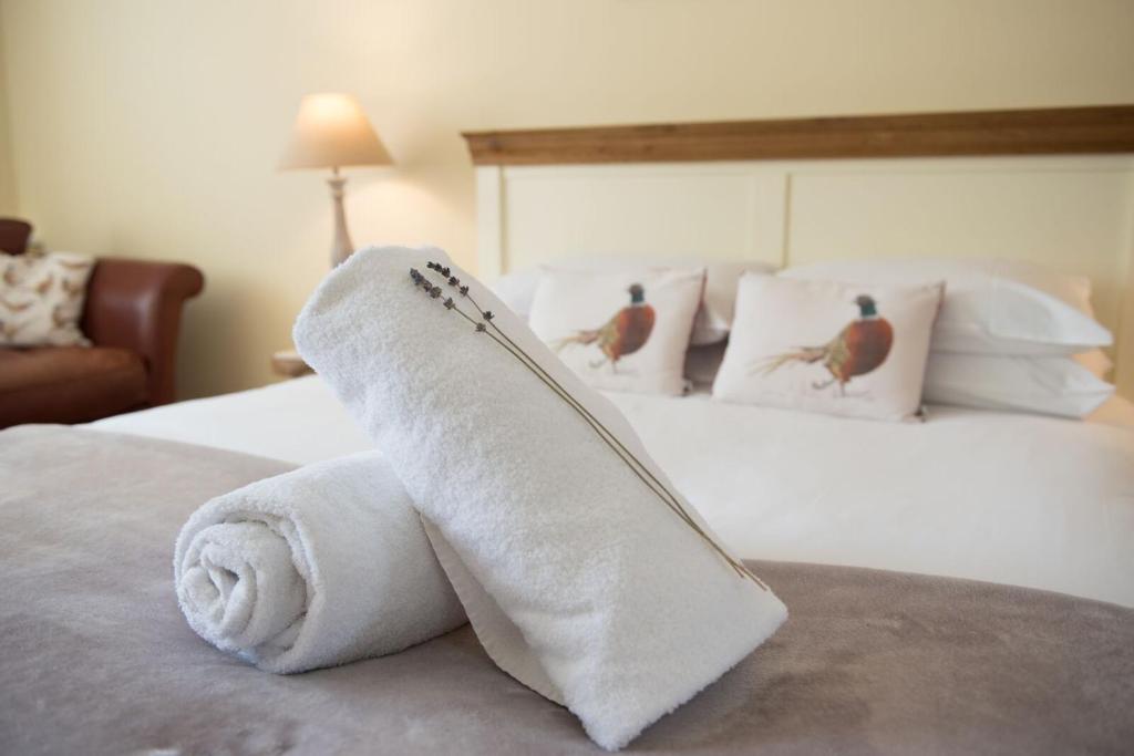 a hotel room with a rolled up towel on a bed at The Lodge at Broadway in Broadway