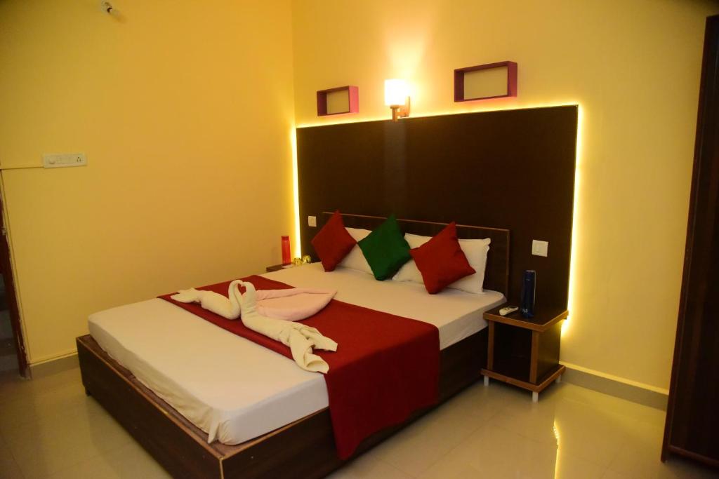 a bedroom with a bed with a person laying on it at Bliss Holiday Inn Goa in Calangute