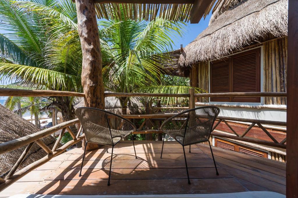 a porch with two chairs and a table on a resort at Delek Tulum in Tulum