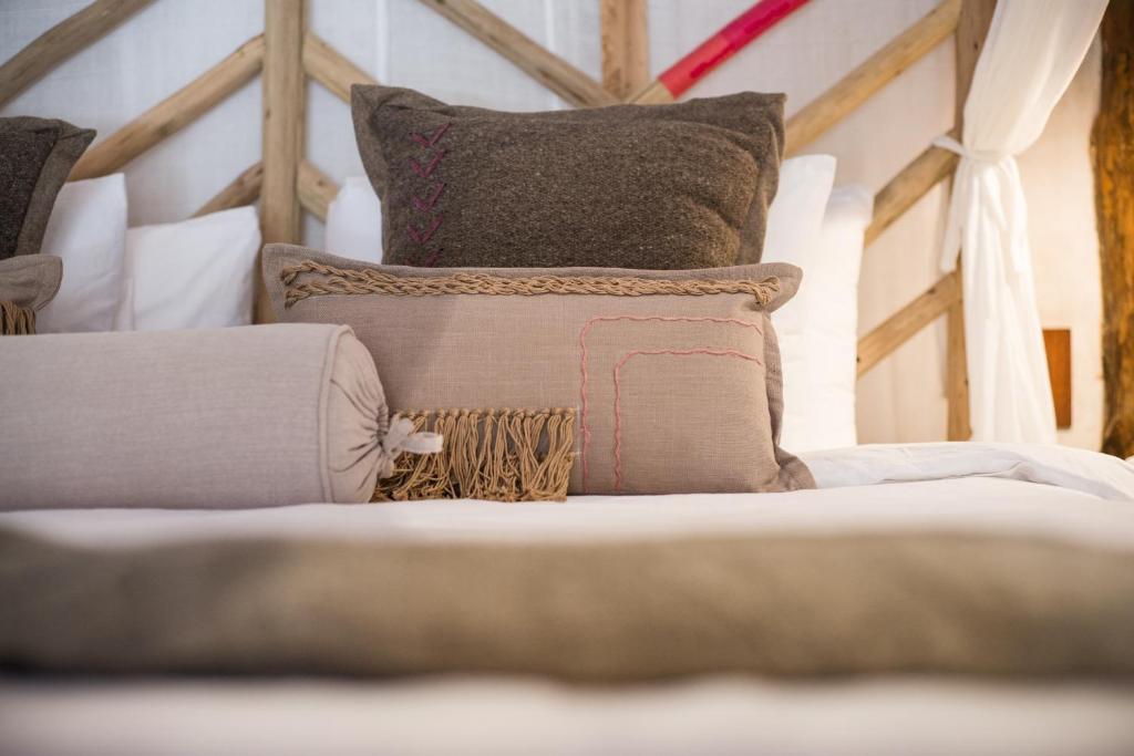 a pile of pillows sitting on top of a bed at Delek Tulum in Tulum