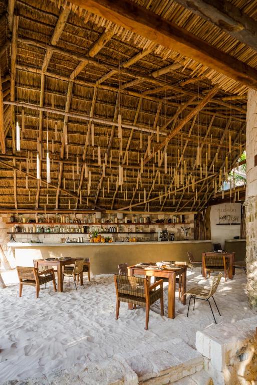 a dining room with tables and chairs in a building at Delek Tulum in Tulum