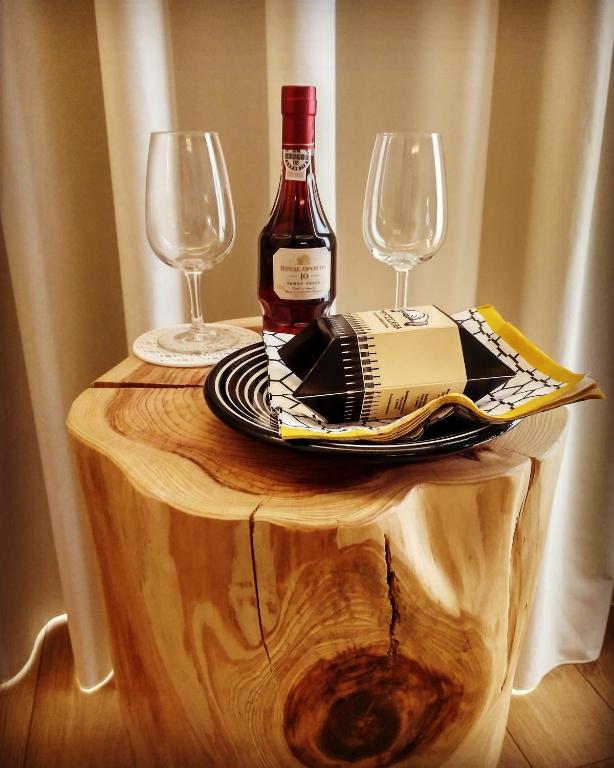 a bottle of wine and two glasses on a wooden table at PicPorto Apartment in Porto