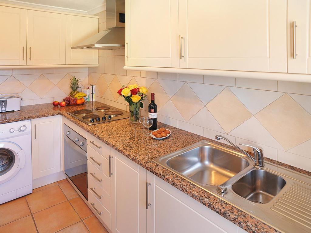 a kitchen with a sink and a counter top at Pestana Palm Gardens in Carvoeiro