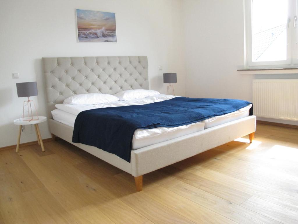 Hygge Apartments Bonn في بون: غرفة نوم بسرير كبير مع بطانية زرقاء