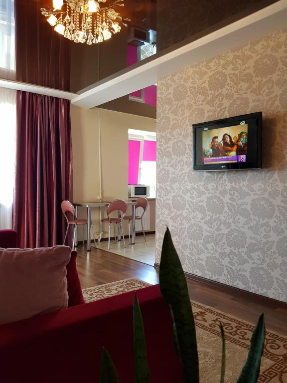 - un salon avec un canapé et une télévision murale dans l'établissement Апартаменты с балконом, à Kharkov