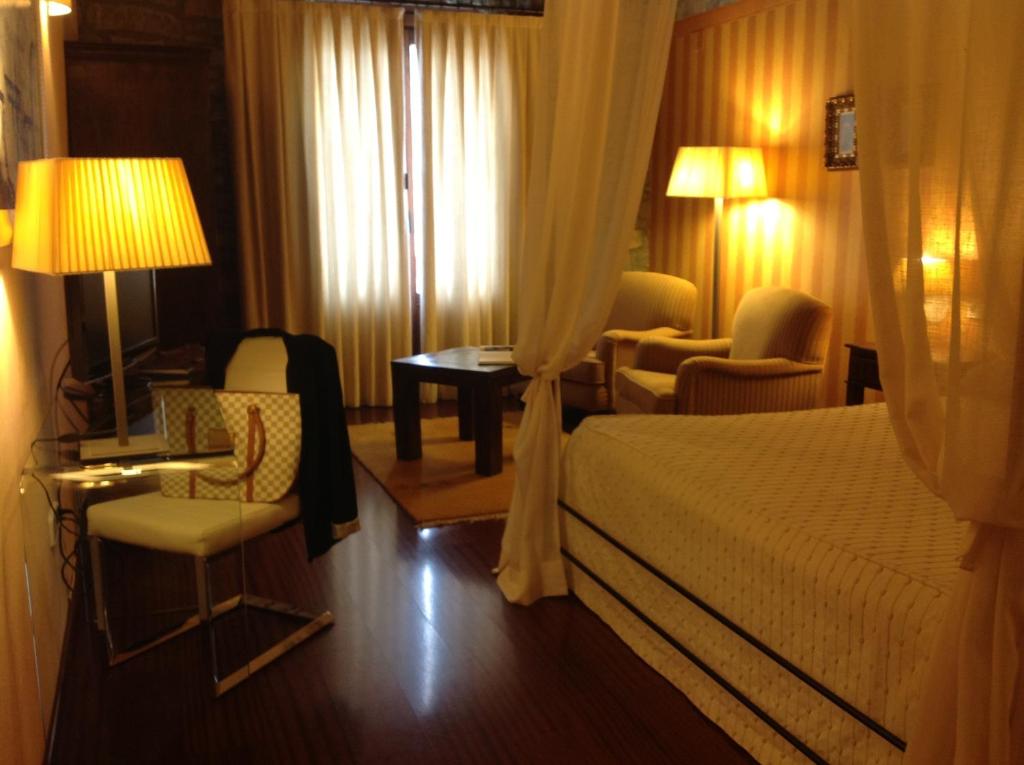 a hotel room with a bed and a table and chairs at Los Arcos in Aínsa