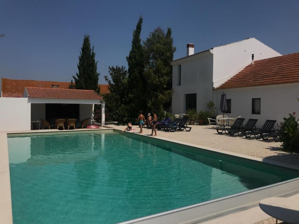 a swimming pool in front of a house at Casas e Glamping Quinta da Saudade in Canha