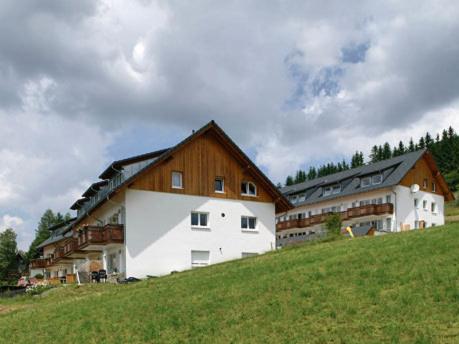 ein großes Gebäude auf einem grünen Hügel in der Unterkunft Wohnpark Schwarzwaldblick Bernau in Bernau im Schwarzwald