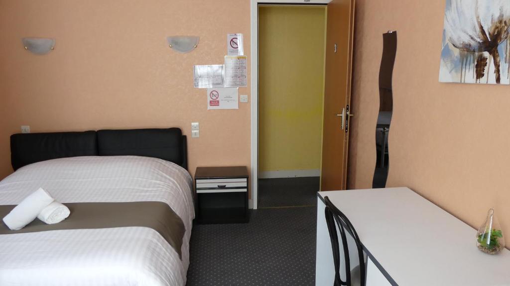 una habitación de hotel con 2 camas y una puerta en Hôtel Duguesclin, en La Haye-Pesnel