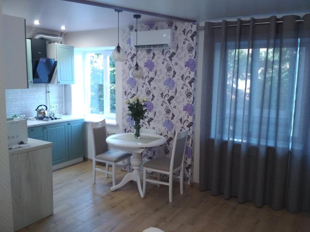 a kitchen with a table and chairs in a kitchen at Apartment "Provence" in Chernihiv