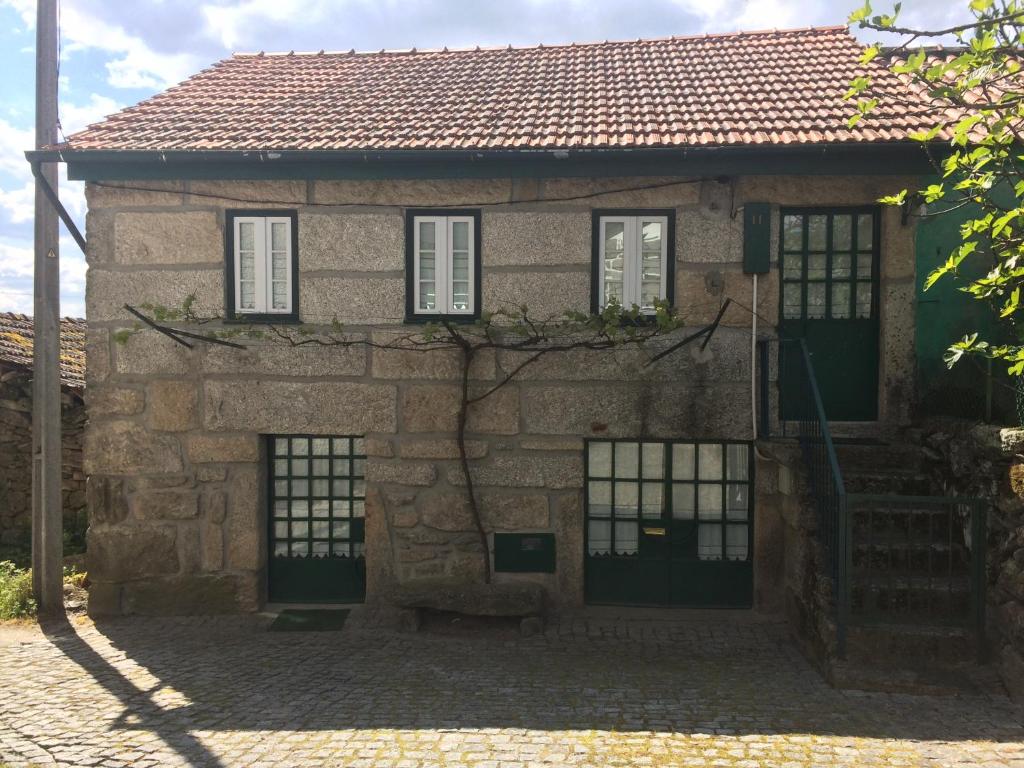 Casa de piedra antigua con ventanas y escalera en Casa da Moita en Moita