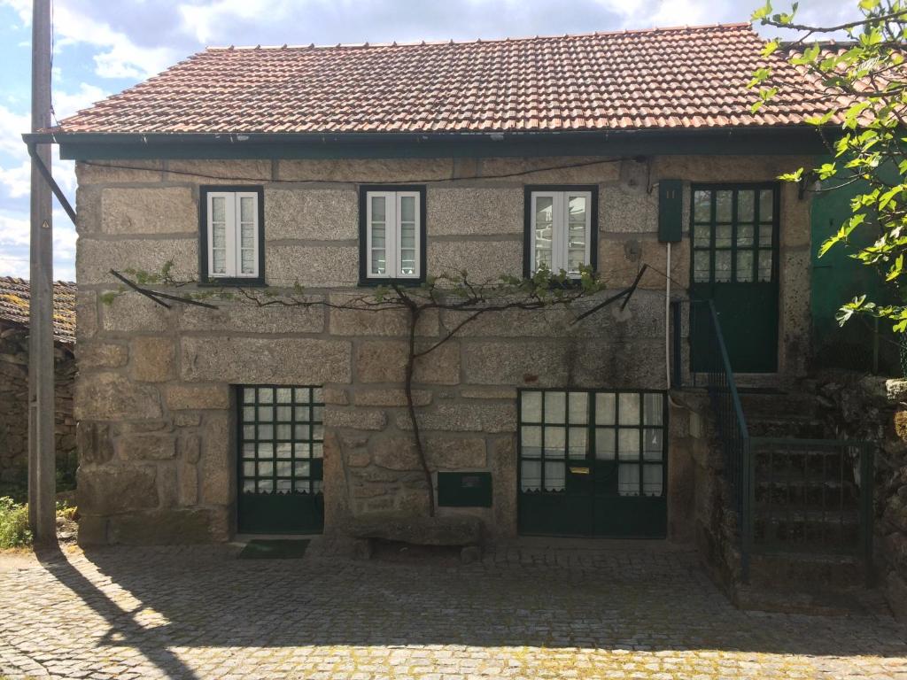 ein altes Steinhaus mit Fenstern und einer Treppe in der Unterkunft Casa da Moita in Moita