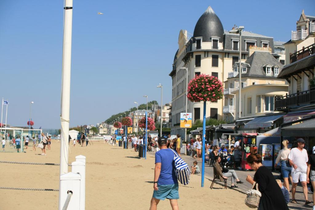 un groupe de personnes marchant sur la plage dans l'établissement Studio en plein coeur de Trouville, à Trouville-sur-Mer