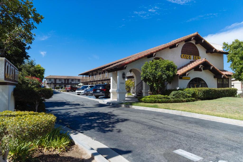 a building with a car parked in front of a street at Cozy Inn in Costa Mesa